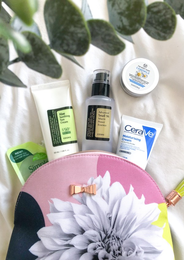 Makeup bag with travel-size beauty products spilling out